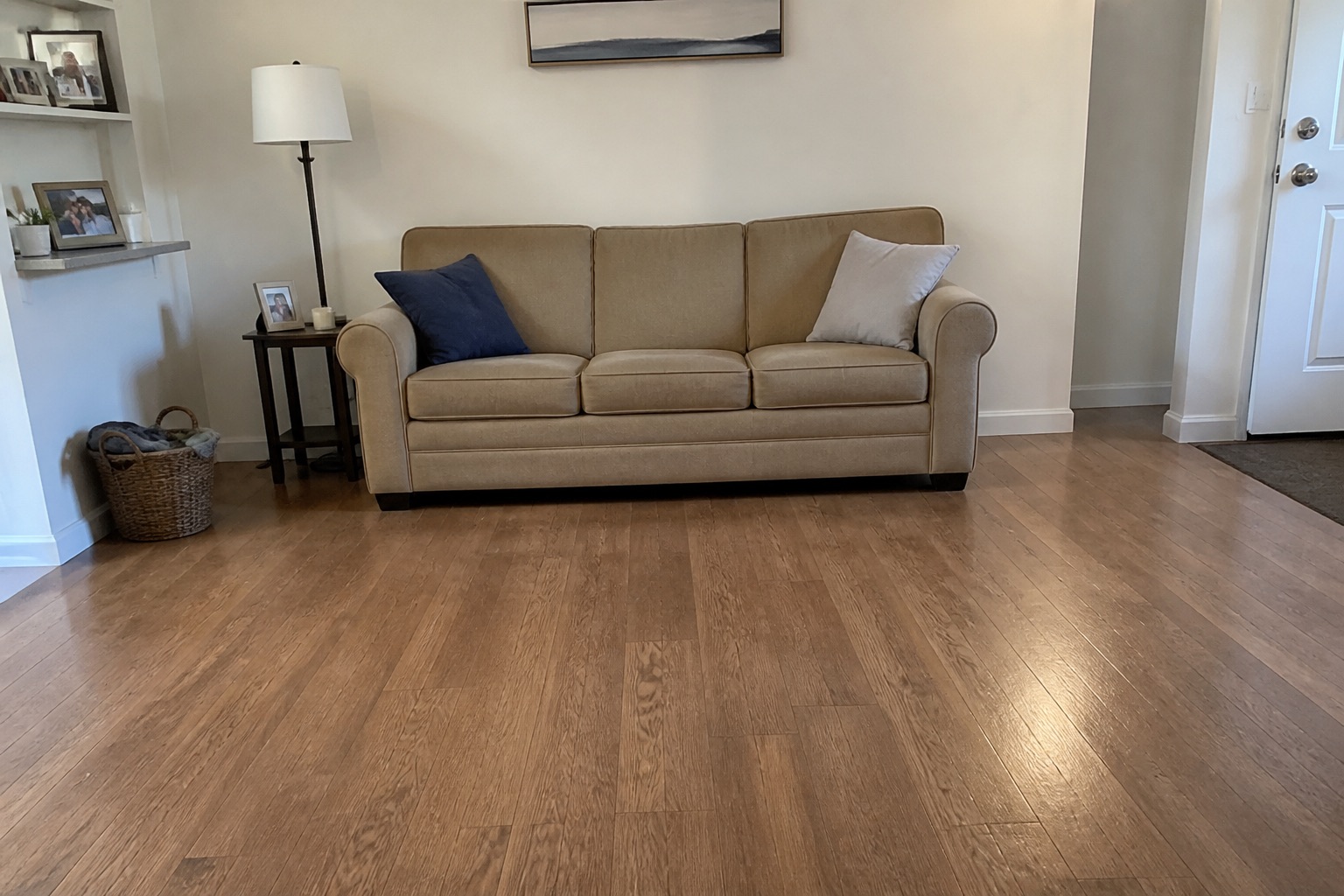 Room with beige sofa on a wood floor, before